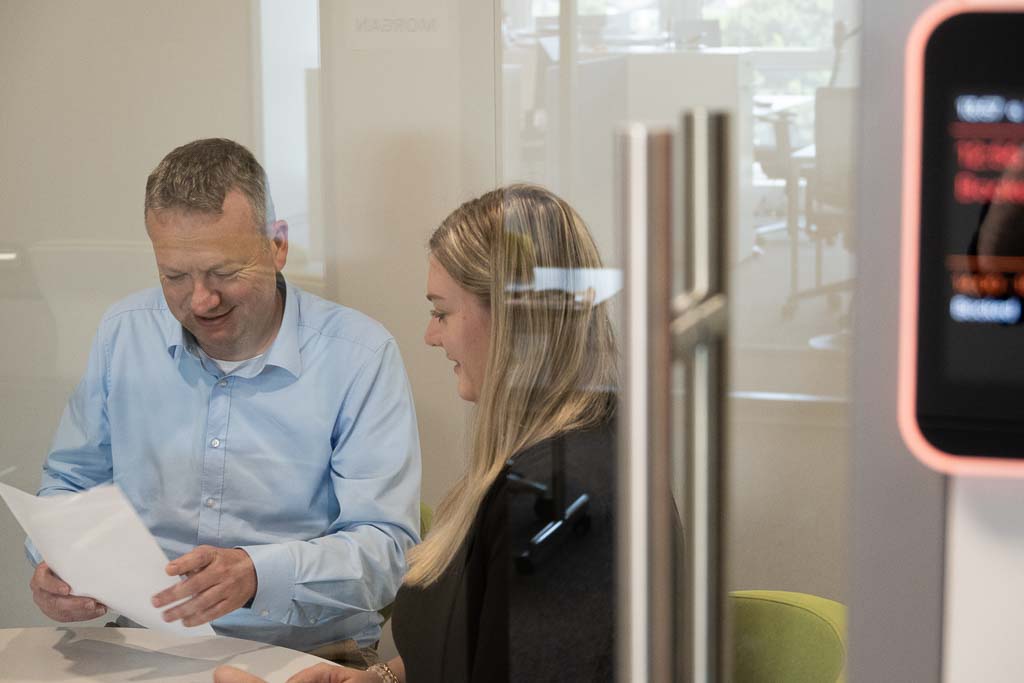 Nicole with another colleague from STRATEC in a closed meeting room with a see-through glass door
