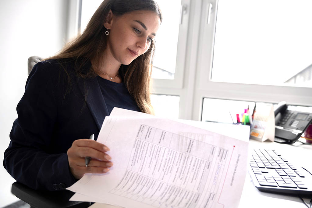 Hanna from STRATEC going through some paper work while sitting on her desk
