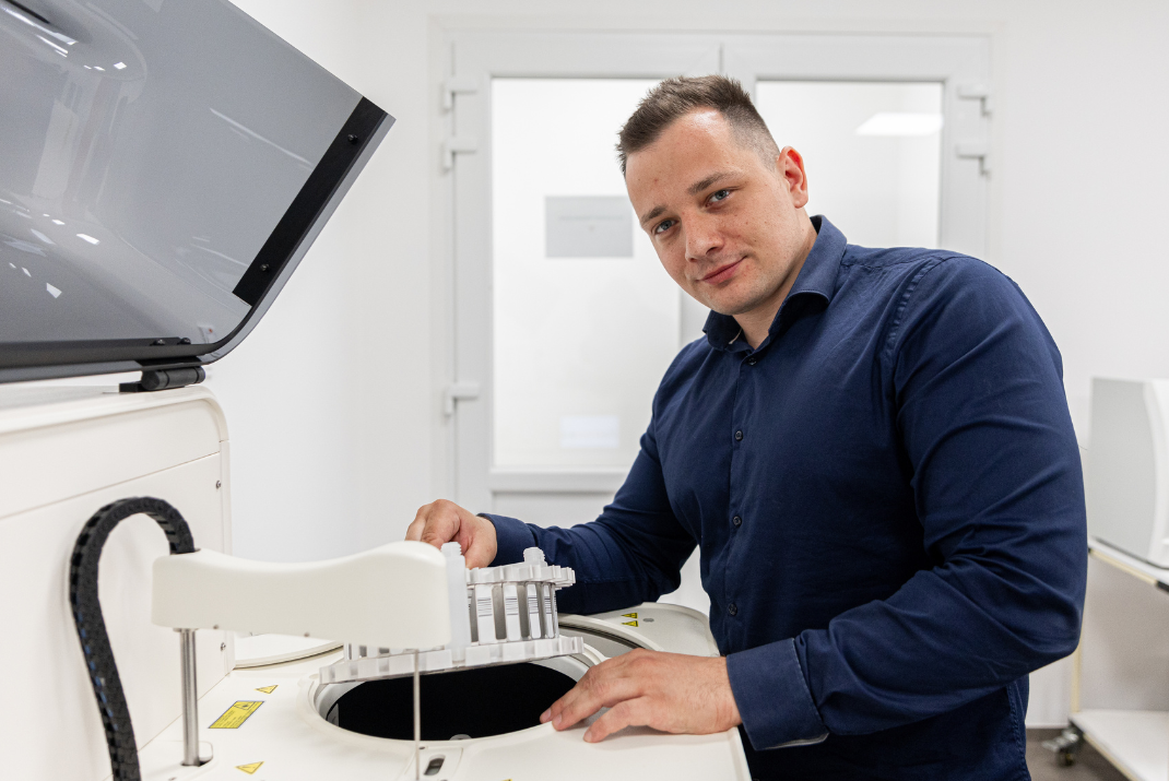 Ádám from Diatron holding the testing rack in front of an instrumentation