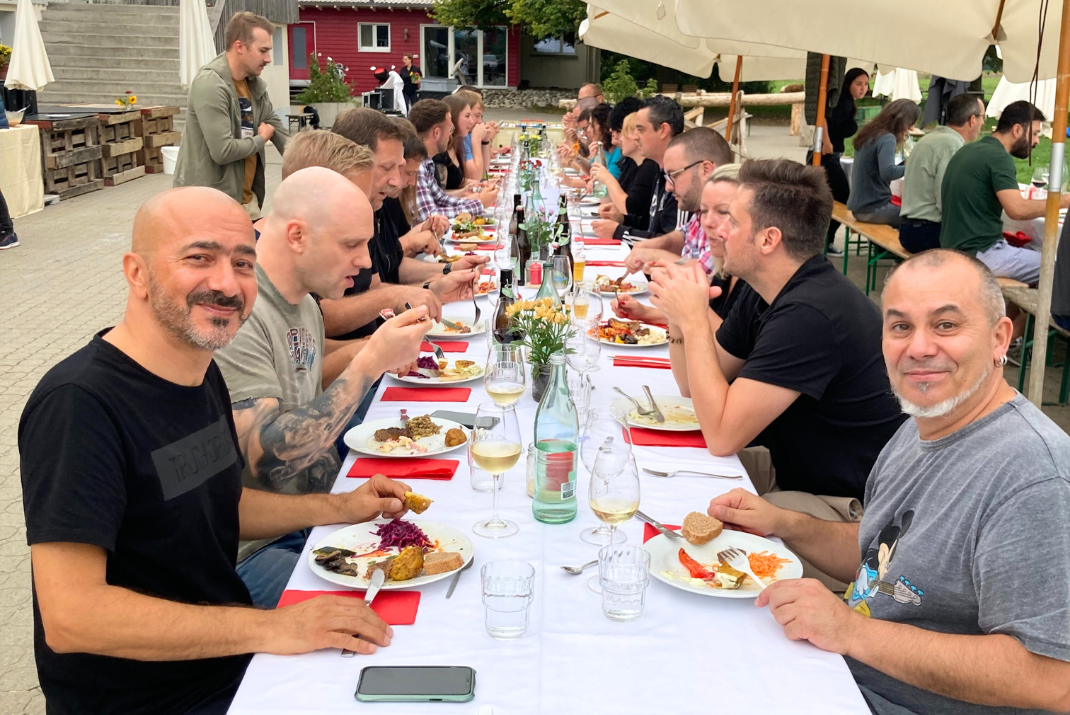 A group of STRATEC employees enjoying dinner together outside at STRATEC Switzerland