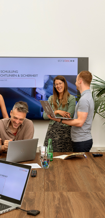 STRATEC employees during a meeting in front of a bigger screen in Austria