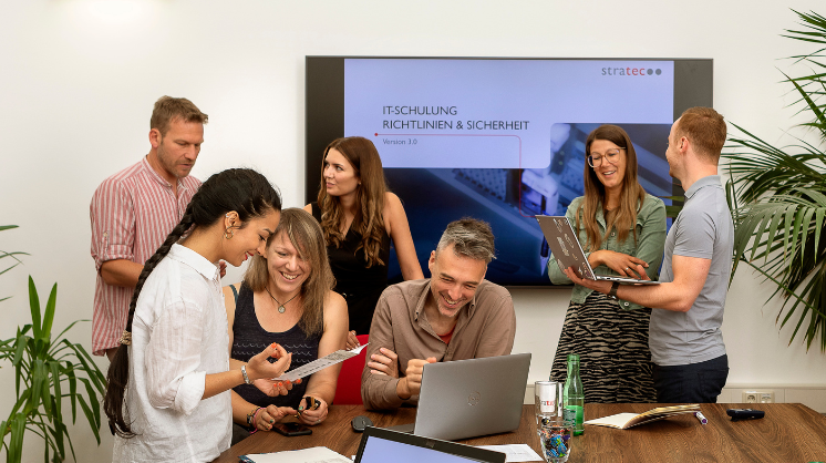 STRATEC employees during a meeting in front of a bigger screen in Austria