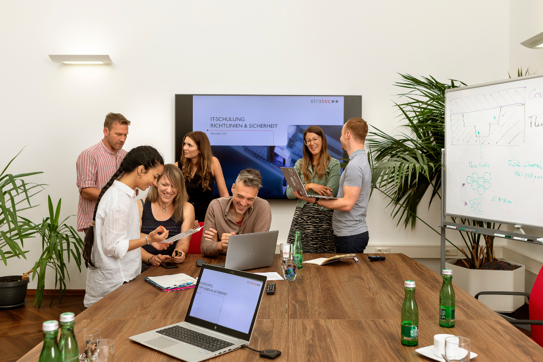 STRATEC employees during a meeting in front of a bigger screen in Austria