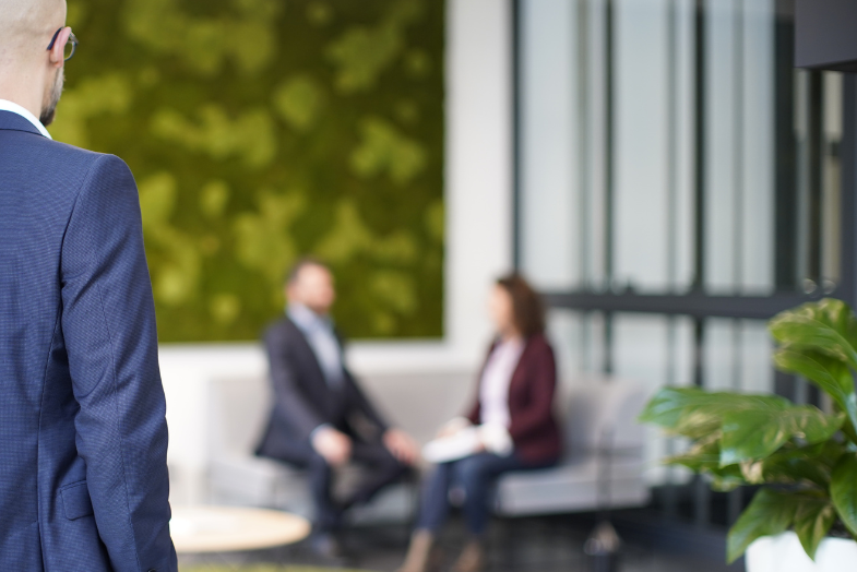 STRATEC employee looking at two other colleagues sitting on the sofa in the reception area