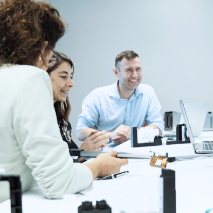 STRATEC employees sitting on a desk in the office laughing