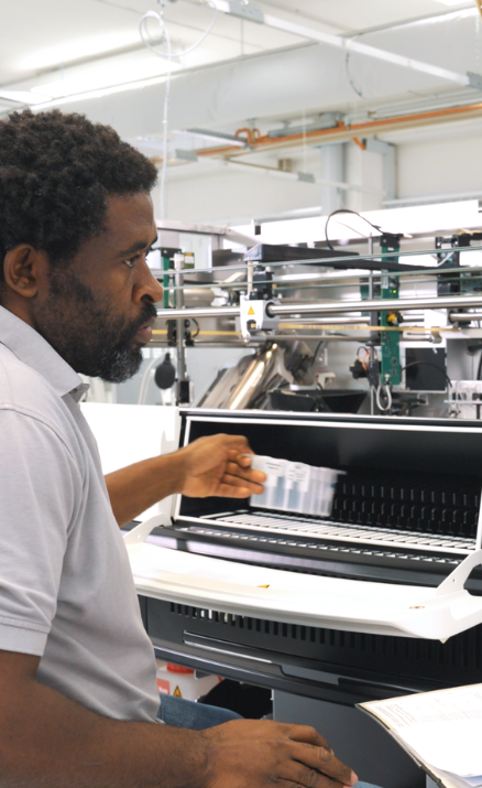 STRATEC employee testing an analyzer system’s functionality in the production hall 