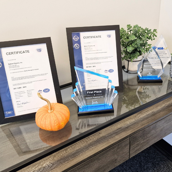 Certifications and awards of Natech placed on a glass wooden table 