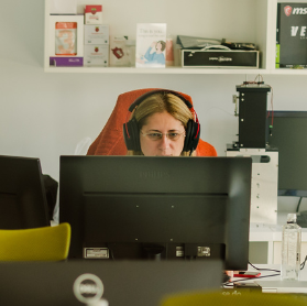 STRATEC colleague in an office in front of a desk sitting in a meeting call in Romania