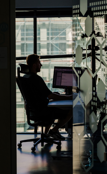 STRATEC employee working in a dark office room on the laptop