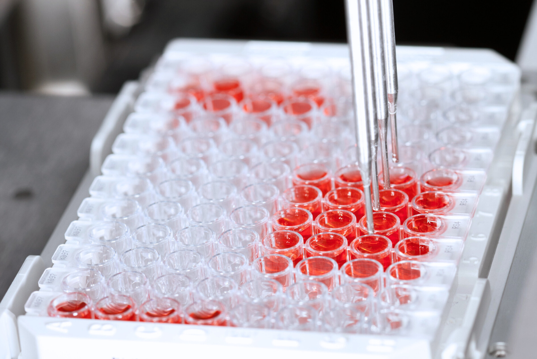 Three steel pipettes from an analyzer system filling up testing tubes in a tube rack at STRATEC