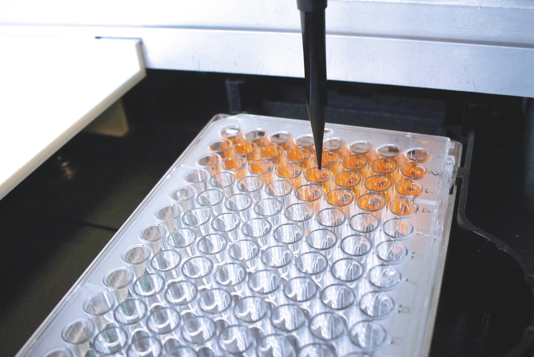 Laboratory machine with one pipette filling up the testing tubes in a tube rack for ELISA testing at Diatron