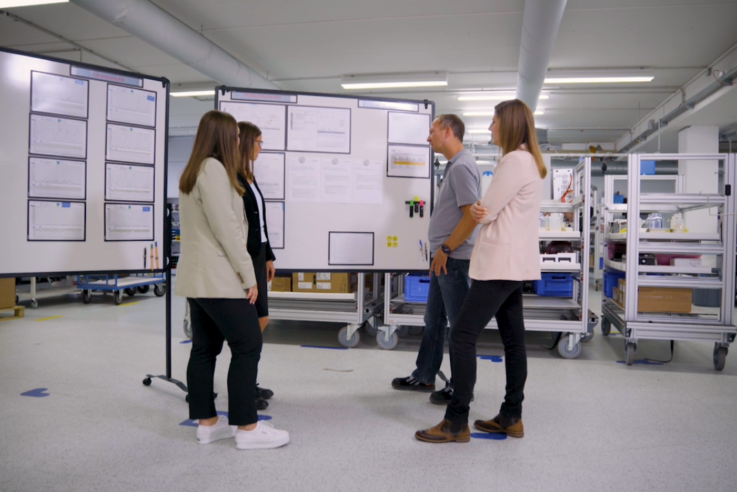 STRATEC employees looking at one of the flipcharts in the production hall in Birkenfeld, Germany