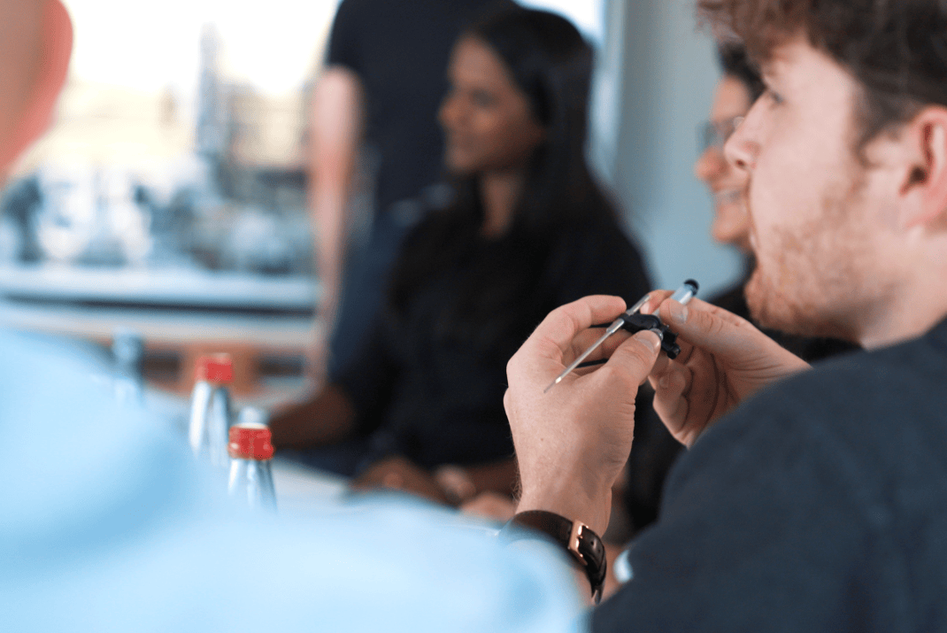 STRATEC employees in a meeting with one colleague holding a pipette in his hand