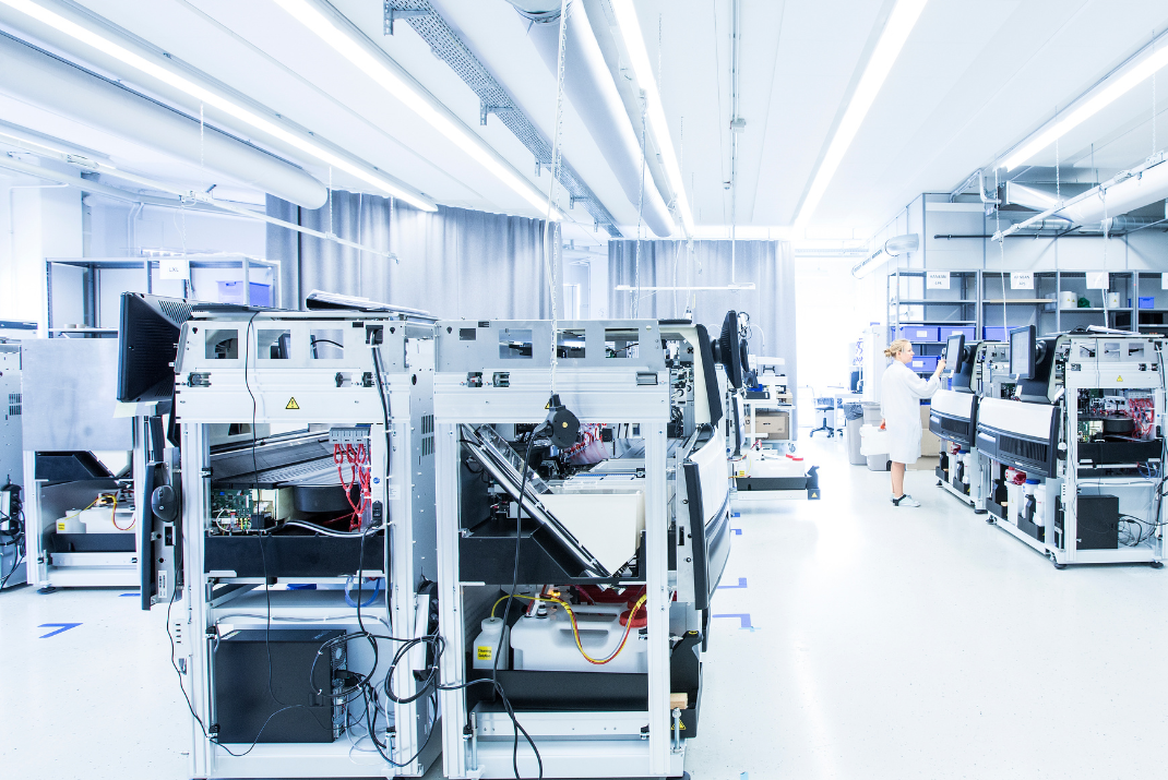 STRATEC employee operating the monitor attached to the instrumentation in the production hall