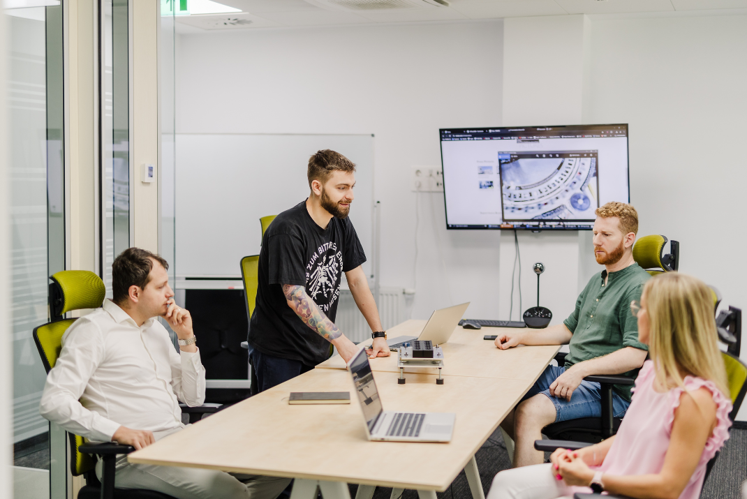 STRATEC employees holding a meeting in a bigger meeting room with a big screen in Romania