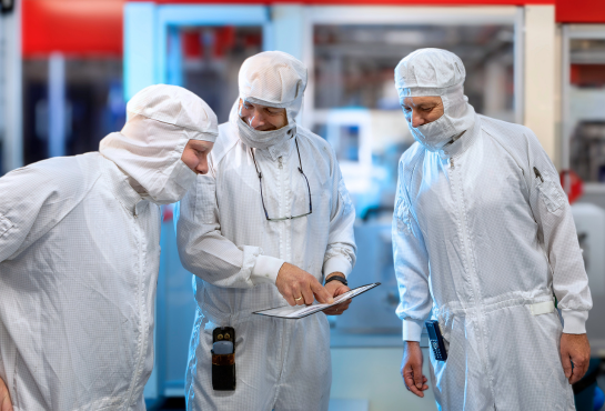Three laboratorians with safety gear talking work